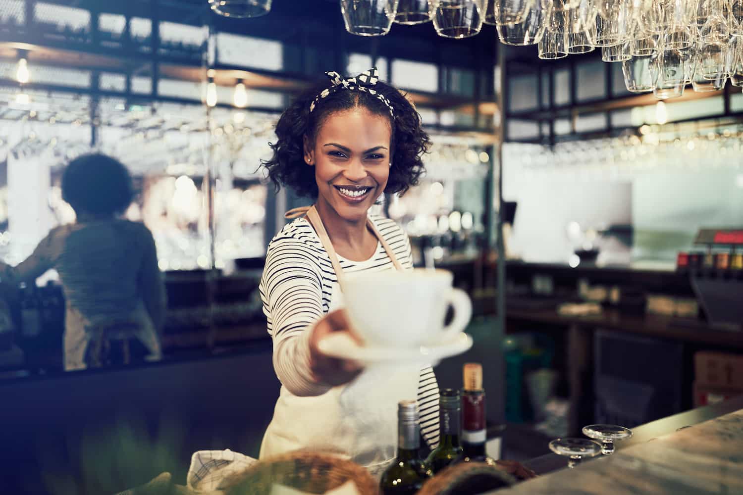 smiling-barista-holding-up-a-fresh-cup-of-coffee-2024-09-16-16-36-31-utc.jpg